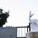 Un cerbiatto di gesso si erge sul cancello di una villa 